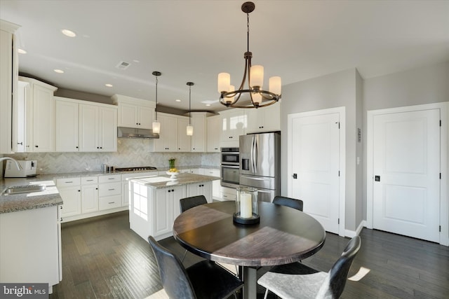 kitchen with white cabinetry, stainless steel appliances, a center island, pendant lighting, and sink