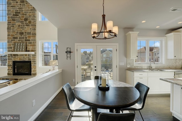 dining room with a healthy amount of sunlight, french doors, sink, and a chandelier