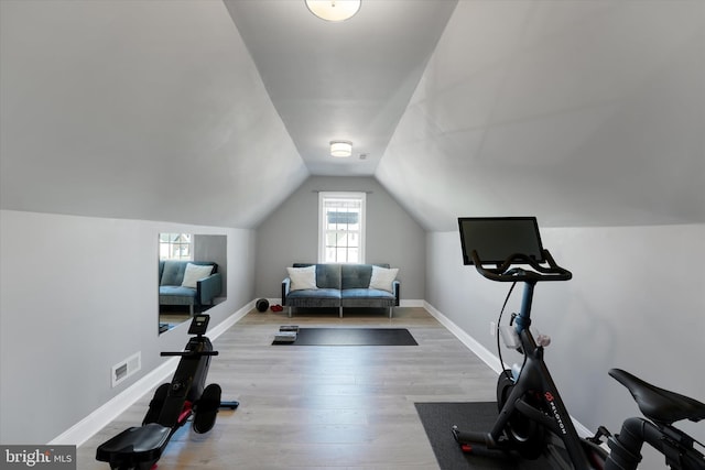 exercise room featuring lofted ceiling and light hardwood / wood-style floors