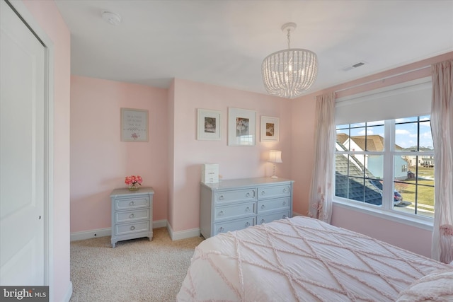 bedroom featuring light carpet and a chandelier