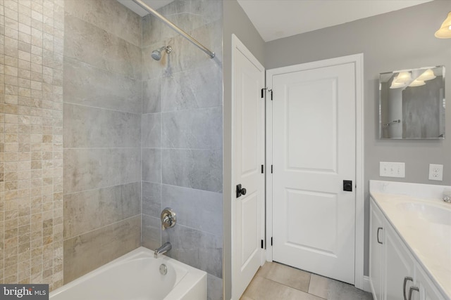 bathroom with tile patterned floors, vanity, and tiled shower / bath