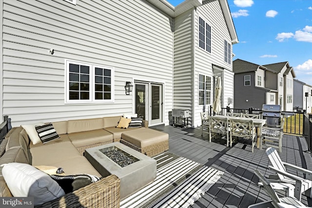 wooden deck featuring grilling area and an outdoor living space with a fire pit