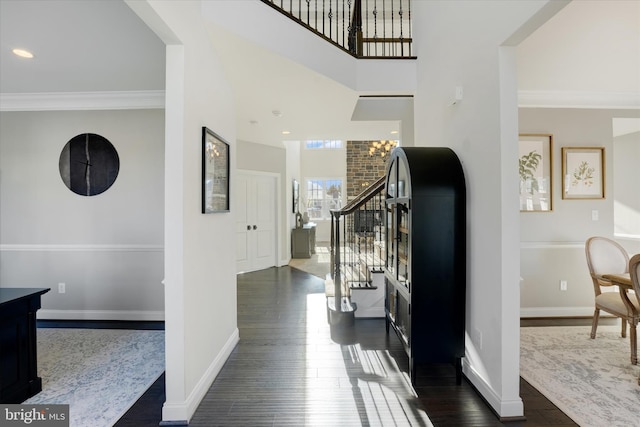 entryway featuring an inviting chandelier, ornamental molding, and dark hardwood / wood-style floors