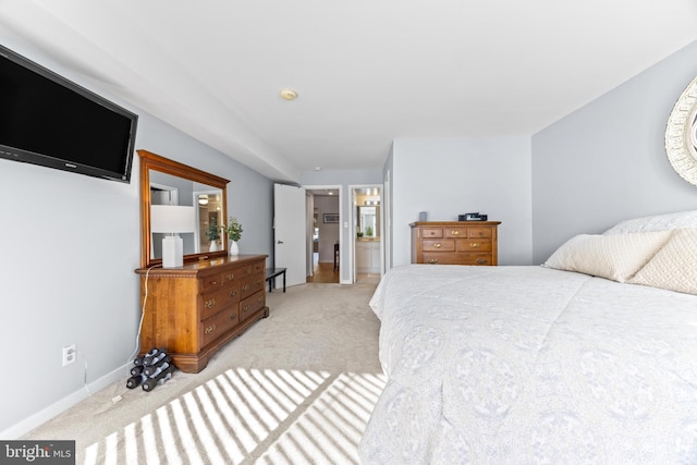 bedroom featuring light colored carpet and connected bathroom