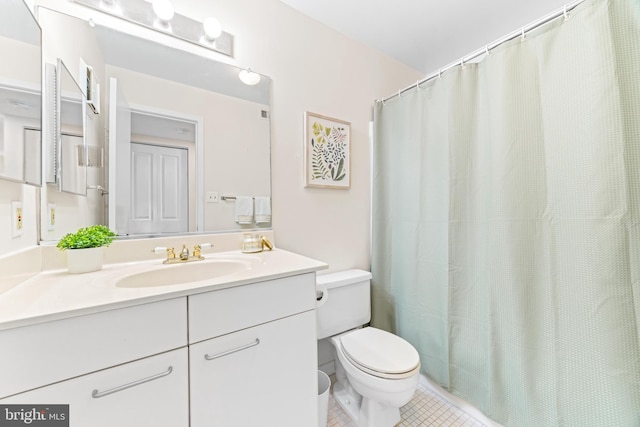 bathroom with toilet, vanity, and tile patterned flooring