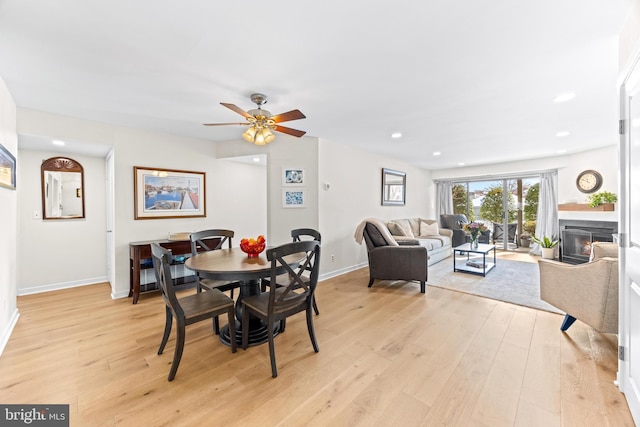 dining space with light wood-type flooring and ceiling fan