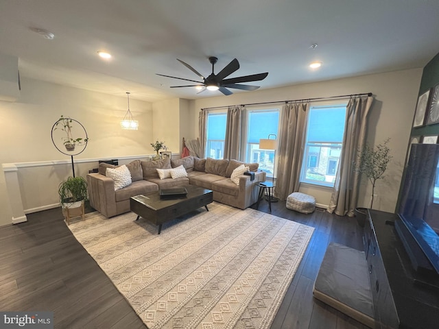 living room featuring ceiling fan with notable chandelier and wood-type flooring