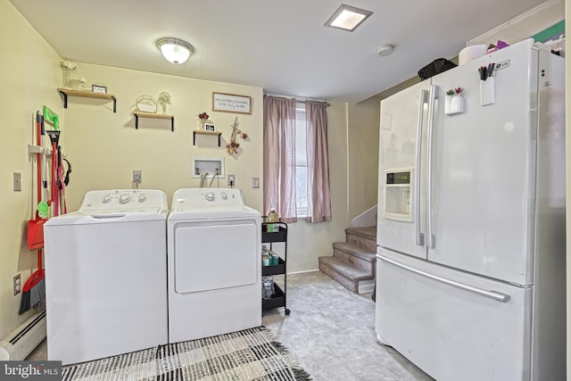 clothes washing area with baseboard heating and washer and dryer