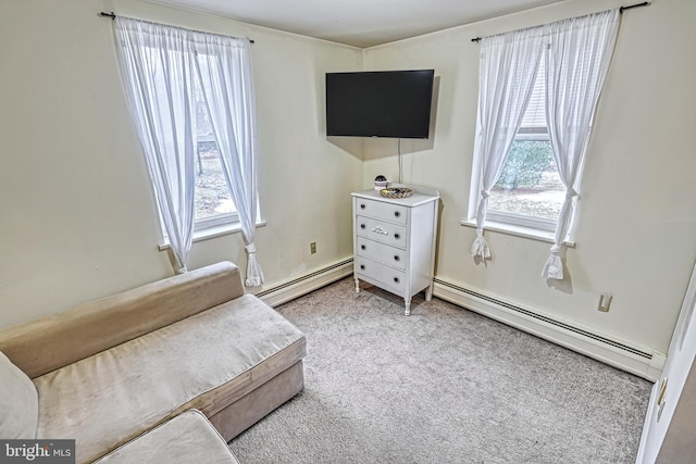 living area featuring a baseboard radiator, a healthy amount of sunlight, and light colored carpet