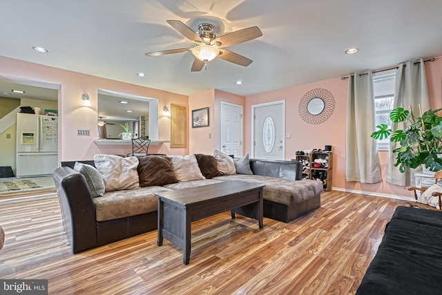 living room featuring light wood-type flooring and ceiling fan