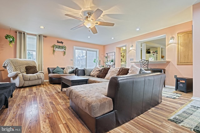 living room featuring ceiling fan and light hardwood / wood-style flooring