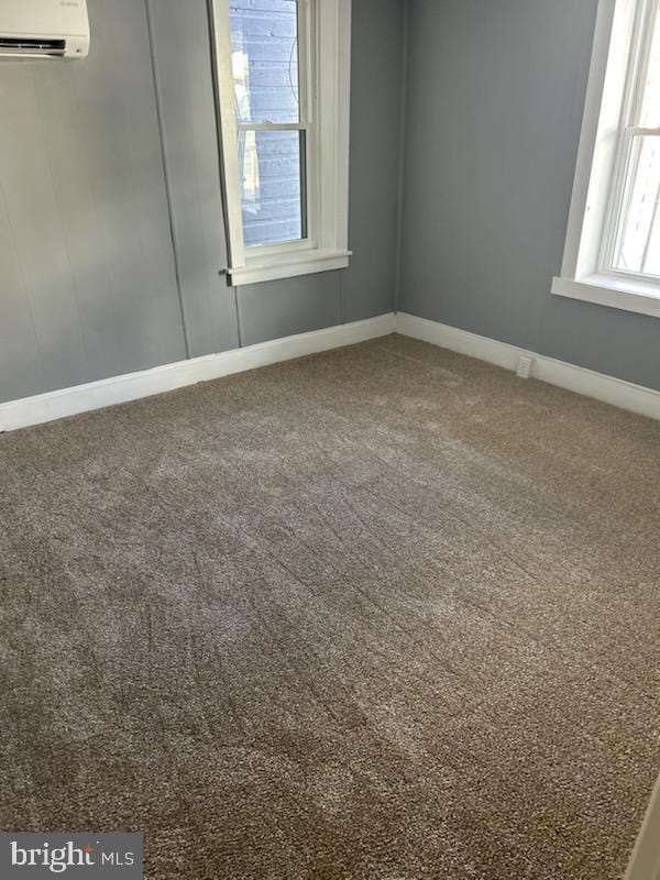 empty room with carpet flooring and a wall mounted AC