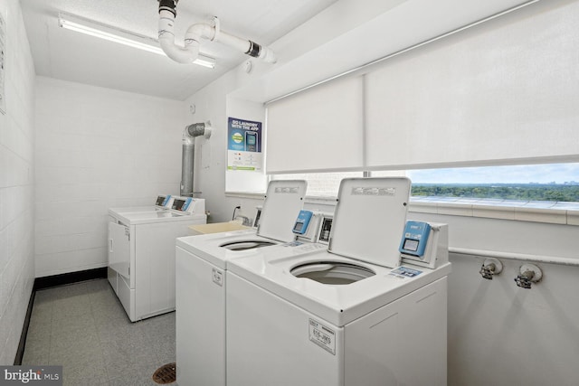 clothes washing area with separate washer and dryer and a wealth of natural light