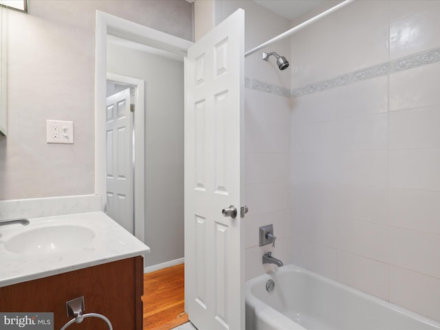 bathroom with vanity, hardwood / wood-style flooring, and shower / tub combination