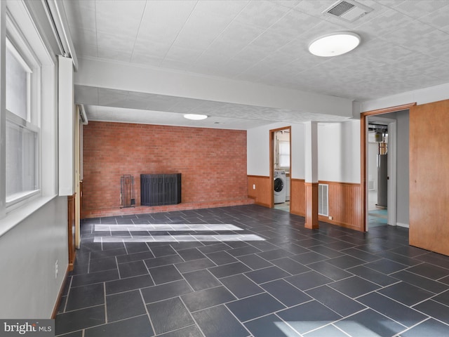 basement with wooden walls and washer / clothes dryer