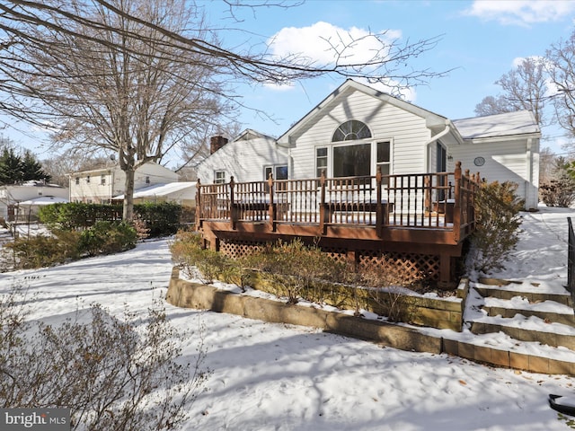 snow covered rear of property featuring a deck