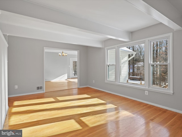 interior space with a notable chandelier, hardwood / wood-style flooring, and beamed ceiling