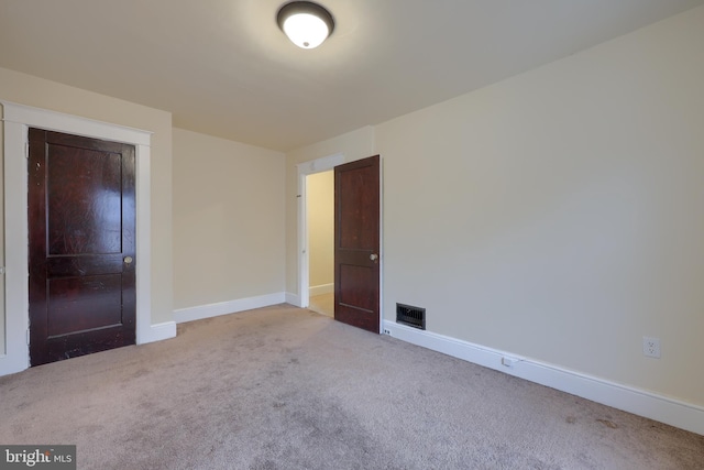 unfurnished bedroom with light carpet and a closet