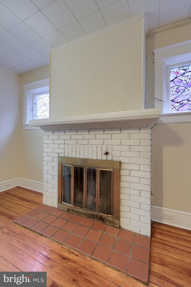 room details featuring a fireplace, wood-type flooring, and crown molding