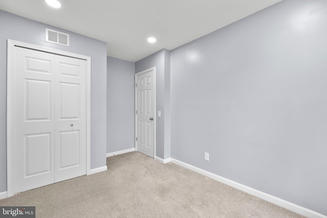 interior space featuring light colored carpet and a closet