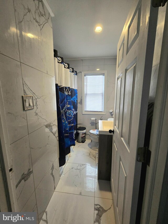 bathroom with vanity, toilet, ornamental molding, and walk in shower
