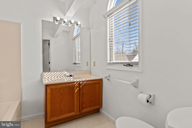 bathroom featuring toilet, tile patterned floors, a wealth of natural light, and vanity