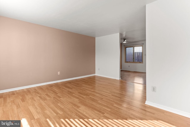 spare room with ceiling fan and light wood-type flooring