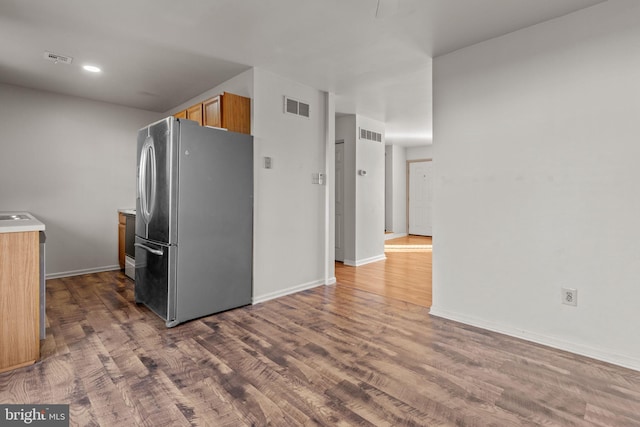 kitchen with dark wood-type flooring and stainless steel fridge