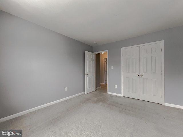 unfurnished bedroom featuring light colored carpet and a closet