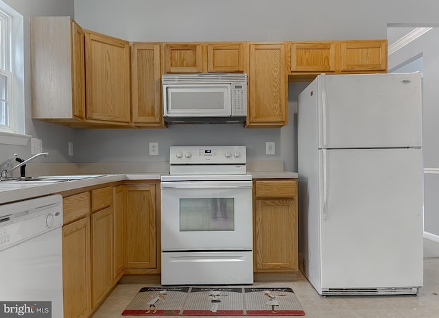 kitchen with light brown cabinets, sink, and white appliances