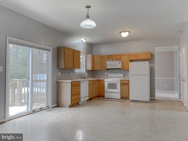 kitchen featuring hanging light fixtures, sink, and white appliances