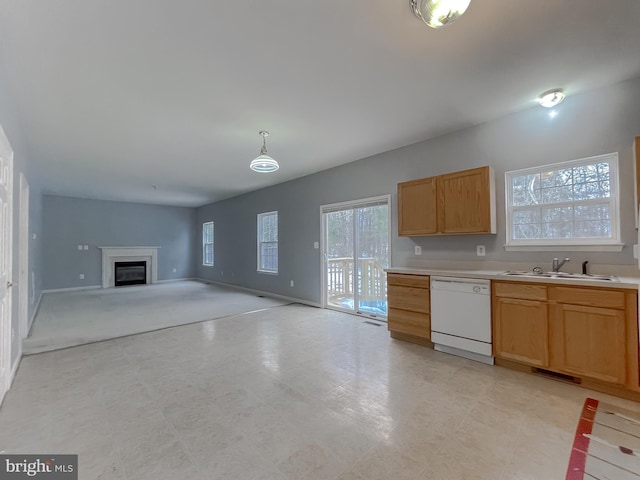 kitchen featuring white dishwasher, hanging light fixtures, and sink