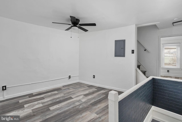 unfurnished room featuring electric panel, hardwood / wood-style flooring, and ceiling fan