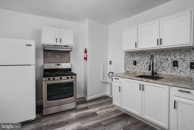 kitchen featuring light stone counters, sink, white refrigerator, white cabinetry, and stainless steel range with gas stovetop