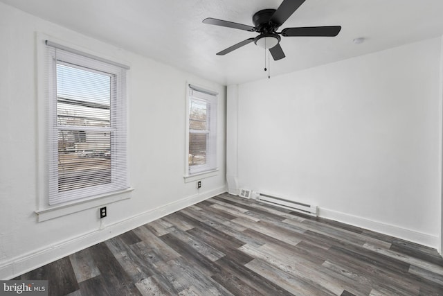 empty room featuring ceiling fan, dark wood-type flooring, and a baseboard heating unit