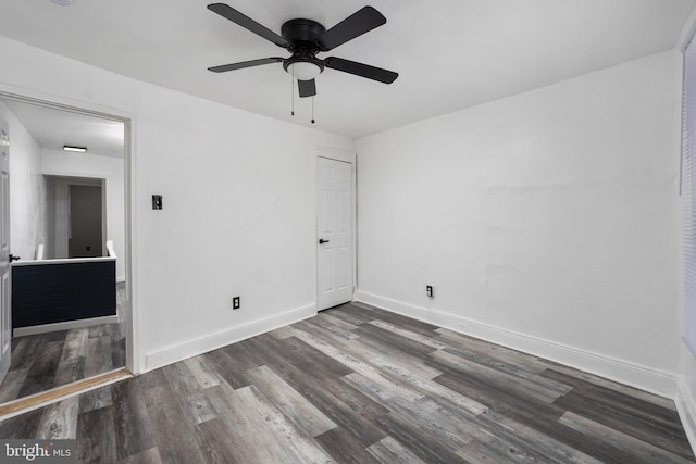 spare room with ceiling fan and dark wood-type flooring