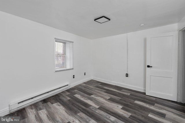 spare room with dark hardwood / wood-style floors and baseboard heating