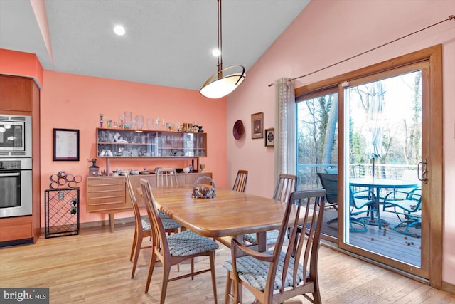 dining space featuring lofted ceiling and light hardwood / wood-style floors