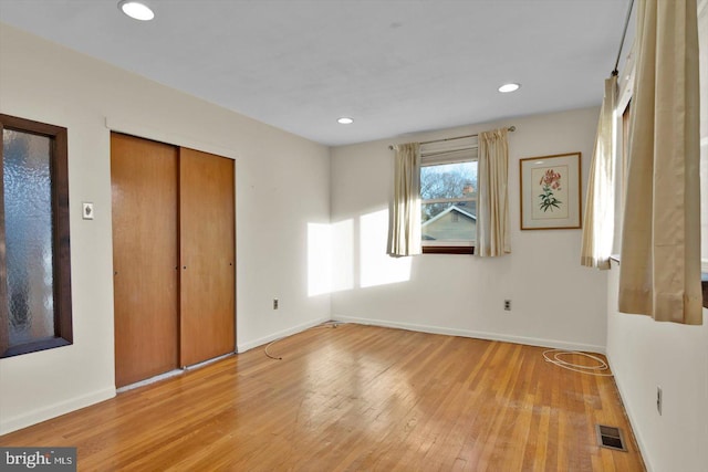 unfurnished bedroom with light wood-type flooring and a closet