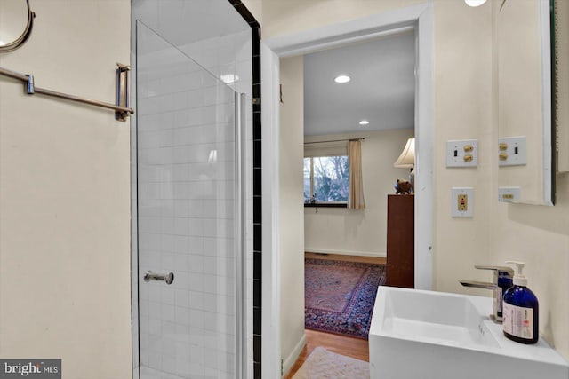 bathroom with sink, walk in shower, and hardwood / wood-style flooring