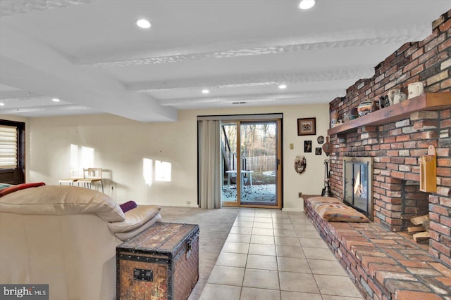 living room with beam ceiling, a fireplace, and light tile patterned floors