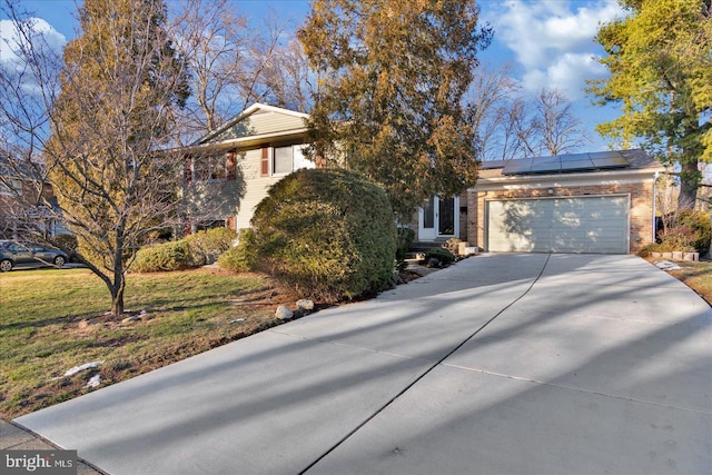 view of front of house featuring solar panels and a garage