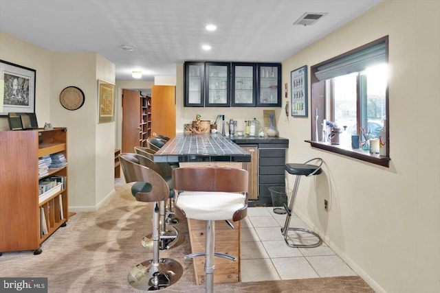 bar featuring light tile patterned flooring and tile counters