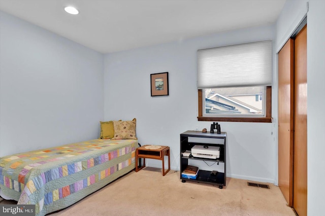 bedroom featuring a closet and light colored carpet