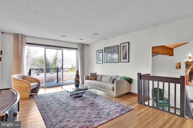 living room with a textured ceiling and light hardwood / wood-style floors