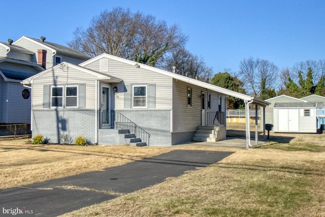 view of front of home with a front yard and a storage shed