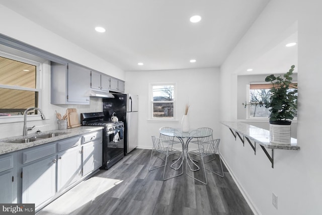 kitchen featuring gray cabinets, stainless steel appliances, dark hardwood / wood-style flooring, decorative backsplash, and sink