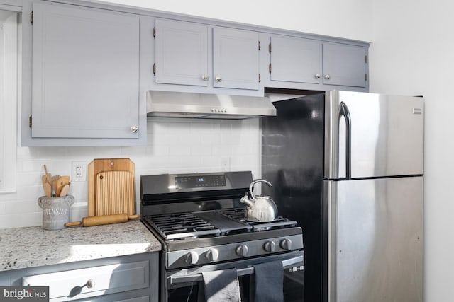 kitchen featuring light stone counters, extractor fan, stainless steel appliances, tasteful backsplash, and gray cabinets