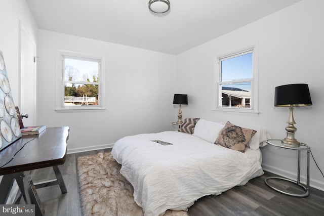 bedroom with dark hardwood / wood-style flooring and multiple windows