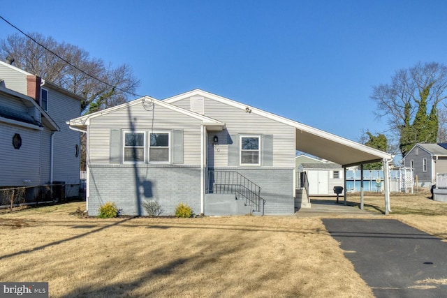 view of front of house with a carport and a front lawn